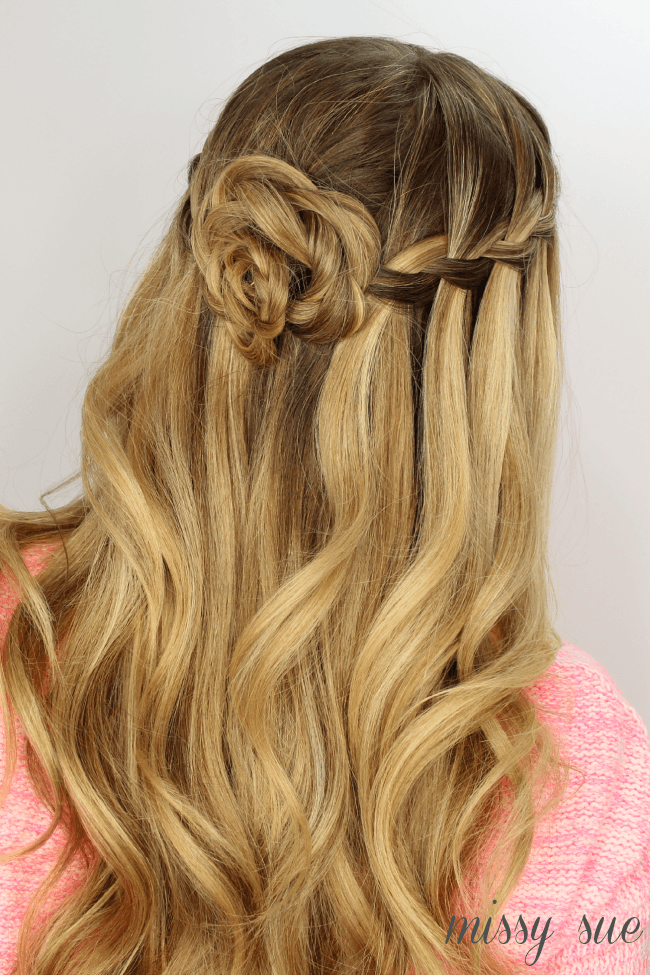 Photo of A twisted bridal bun outlined with white flowers.